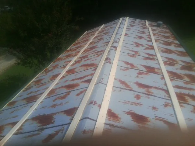 Rusted metal roof panels with new wood purlins before replacement — Storm Damage Roof Repair in Milton by Roofing Brothers