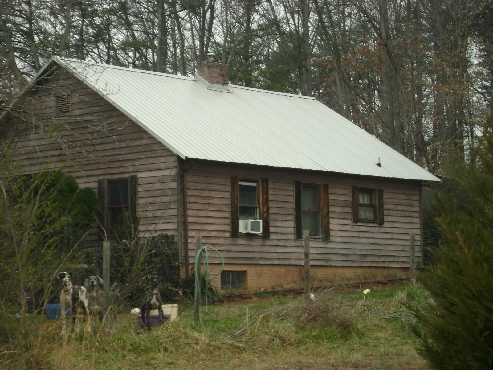 White metal roof on an old wood sided farmhouse, from a Metal Roof Installation job in Milton